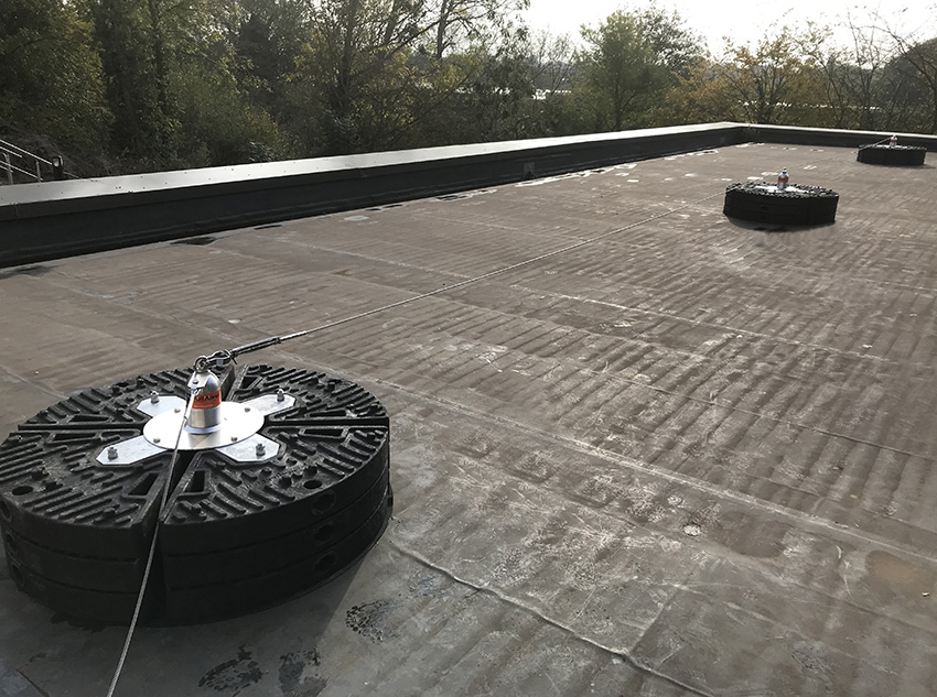 Non-penetrative anchor systems installed on a flat roof for safe working at height
